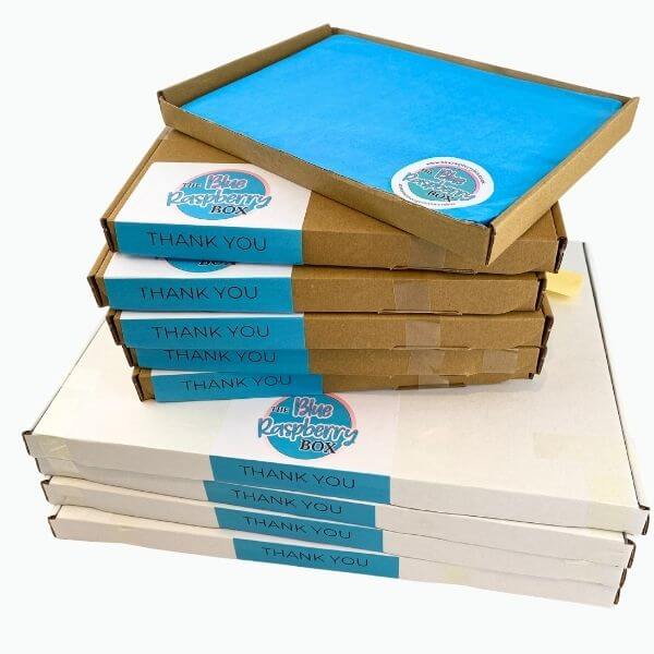 Stack of 'Blue Raspberry Box' letterbox friendly boxes with blue and white labels.