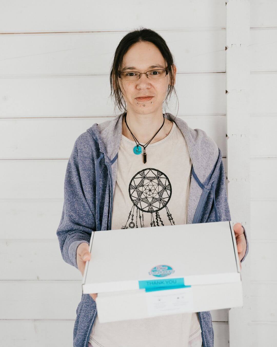 Jeni holding a Blue Raspberry branded box with a white background